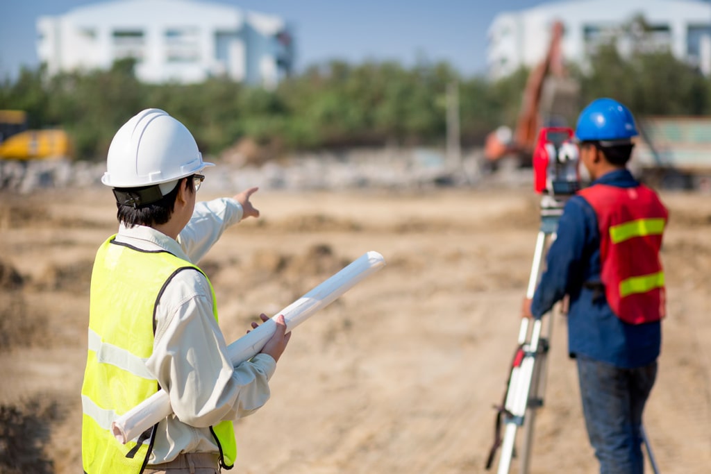 Workers measuring land for amusement park planning and site development