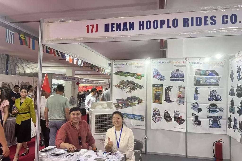 Returning client and park purchasing manager visiting our booth after ordering indoor amusement rides for sale from Hooplo Rides