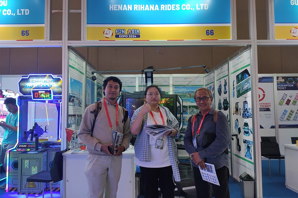 Client interested in small amusement park rides posing for a photo at our booth