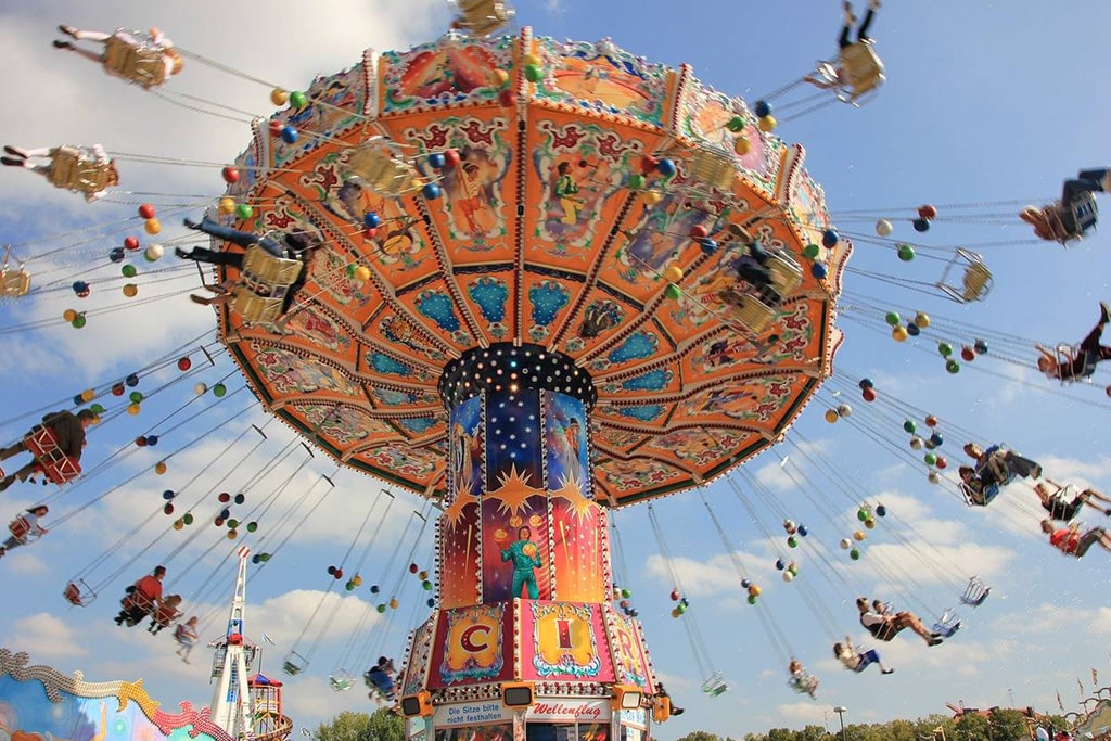 Visitors enjoying wave swinger ride, a popular amusement park ride with flying chairs and fun experience