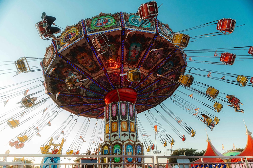 Classic swing carousel ride running with happy riders