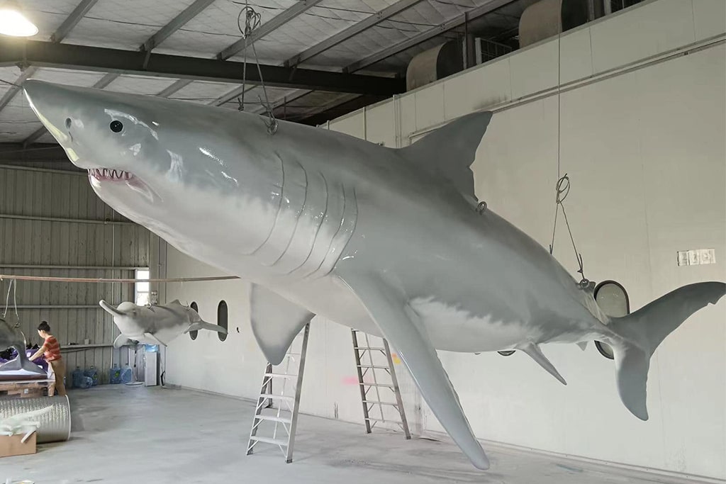 Fiberglass life size shark statue drying after fresh paint in workshop