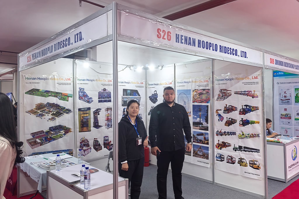 Hooplo Rides team taking a group photo with clients in front of the booth at the Uzbekistan–China Brand Products Exhibition 2025