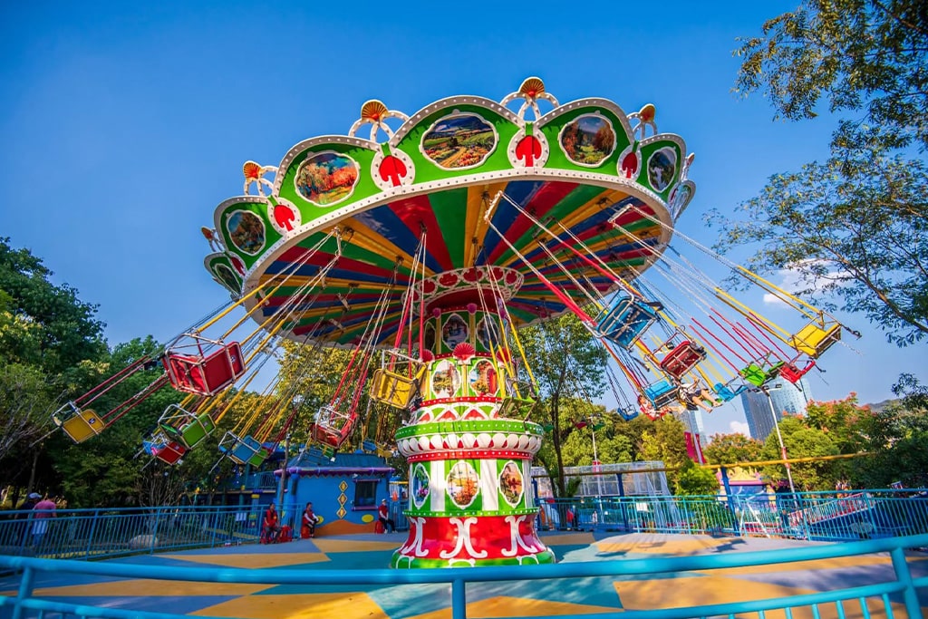 Large swing carousel ride in full operation with riders