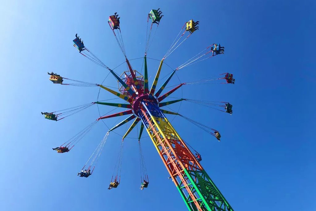 Visitors enjoying the Sky Flyer Ride during daytime, experiencing exciting sky-high flying adventure