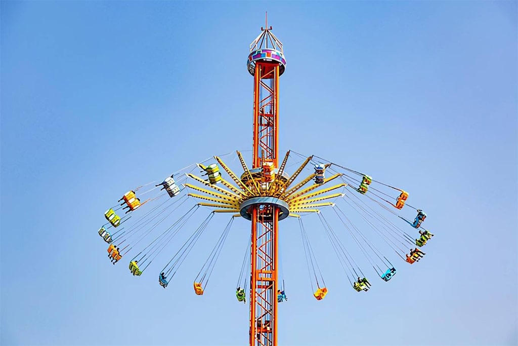 Daytime Sky Flyer Ride with riders spinning high in the air, delivering an unforgettable flying experience