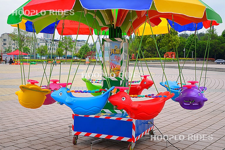 Small swing carousel featuring flying fish decorations
