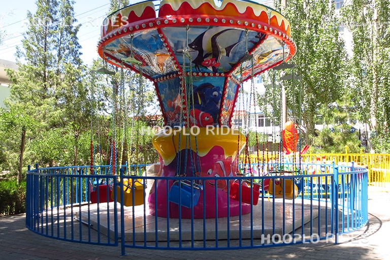 Small swing carousel ride decorated with sea fish design