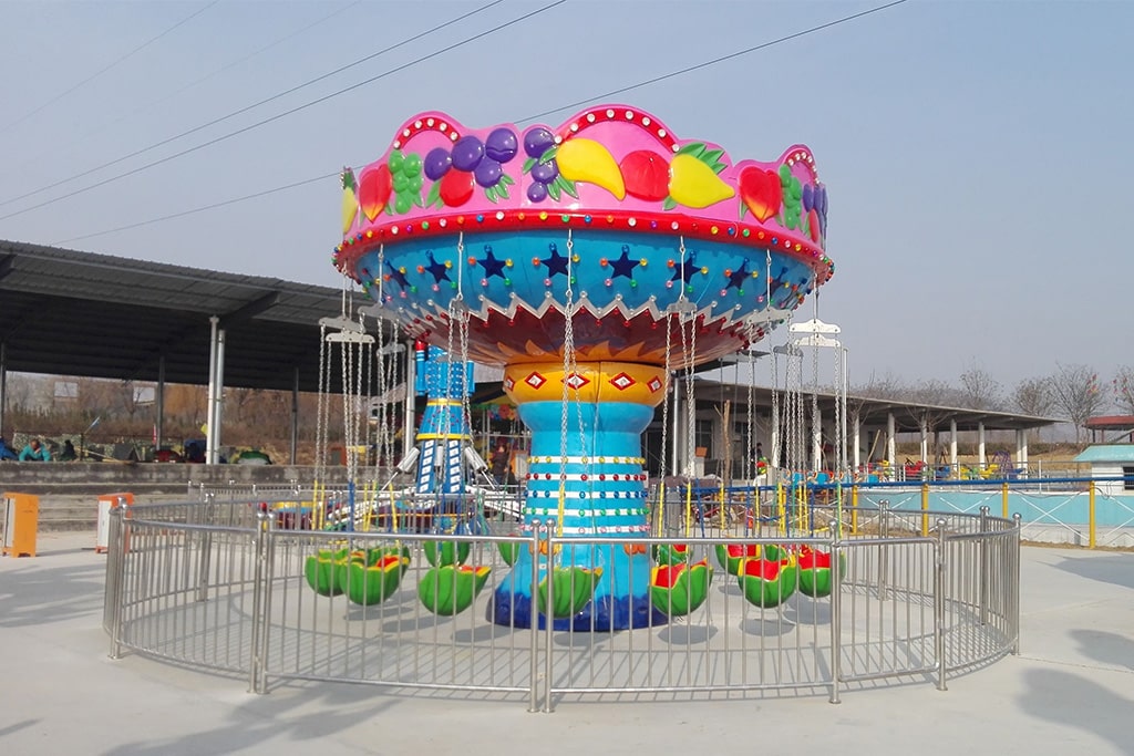 Themed swing carousel with clown and fruit style designs