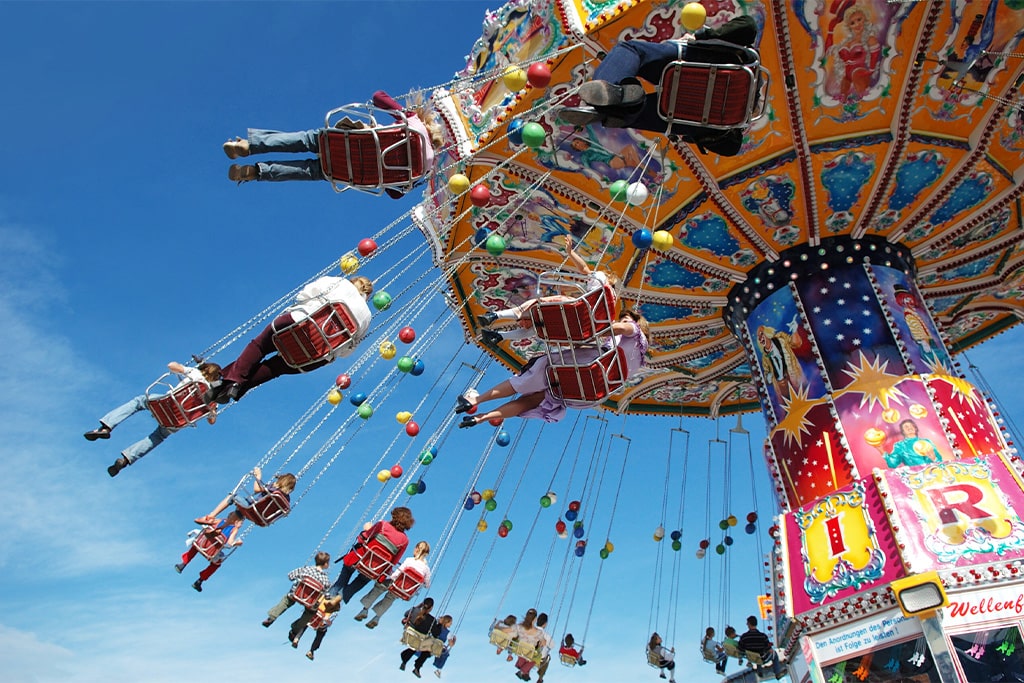 Swing ride in motion at an amusement park with excited riders