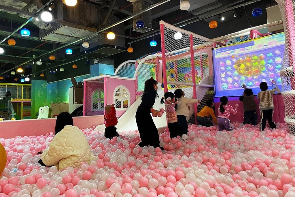 A busy soft play area with parents bringing their children to enjoy the vibrant and colorful play structures, creating a lively atmosphere.