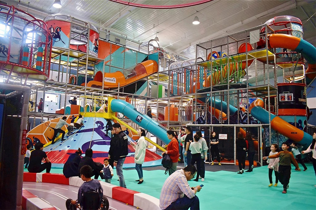 Families enjoying a soft play park, with children and parents engaging in fun activities, creating a joyful and energetic scene.