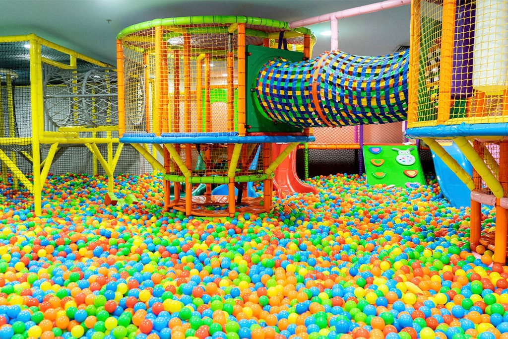 Kids enjoying the ball pit in an indoor playground inside a mall.