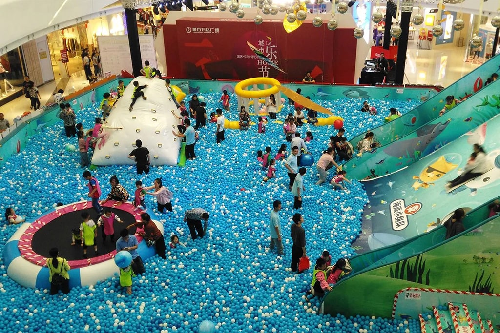 Families enjoying activities inside a popular indoor playground, demonstrating high customer traffic and profitable investment opportunities.