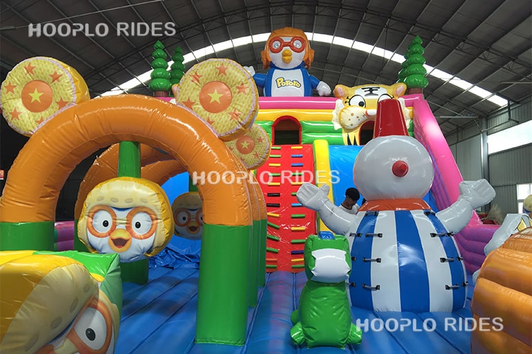 Close-up detail of the central entrance and cartoon penguin elements of the inflatable castle