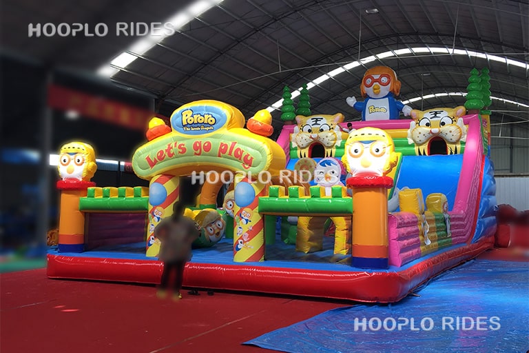 Right view of crazy penguin inflatable castle showing slide and obstacle play areas