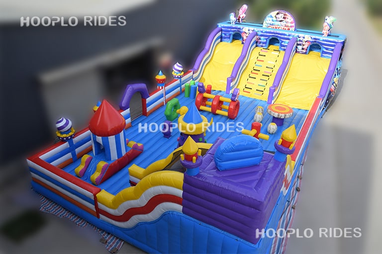 Full left-profile display image of a Fixies-themed inflatable bounce castle with vibrant cartoon details and playful structures.