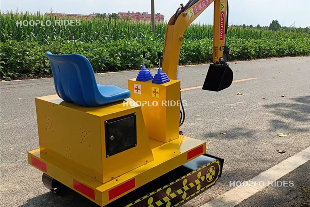 Kids excavator ride playground machine showing the excavator arm and operator seat