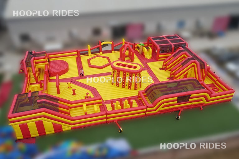 Side view of the Mega Inflatable Obstacle Course Park displaying climbing areas, obstacle lanes, and enclosed challenge sections