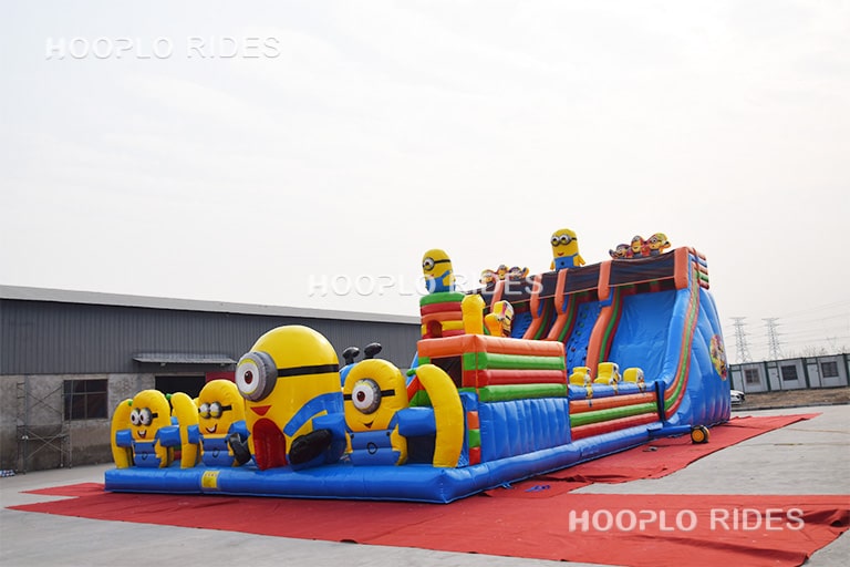 Left side view of a Minions theme inflatable castle featuring colorful character artwork and sturdy inflatable structure.