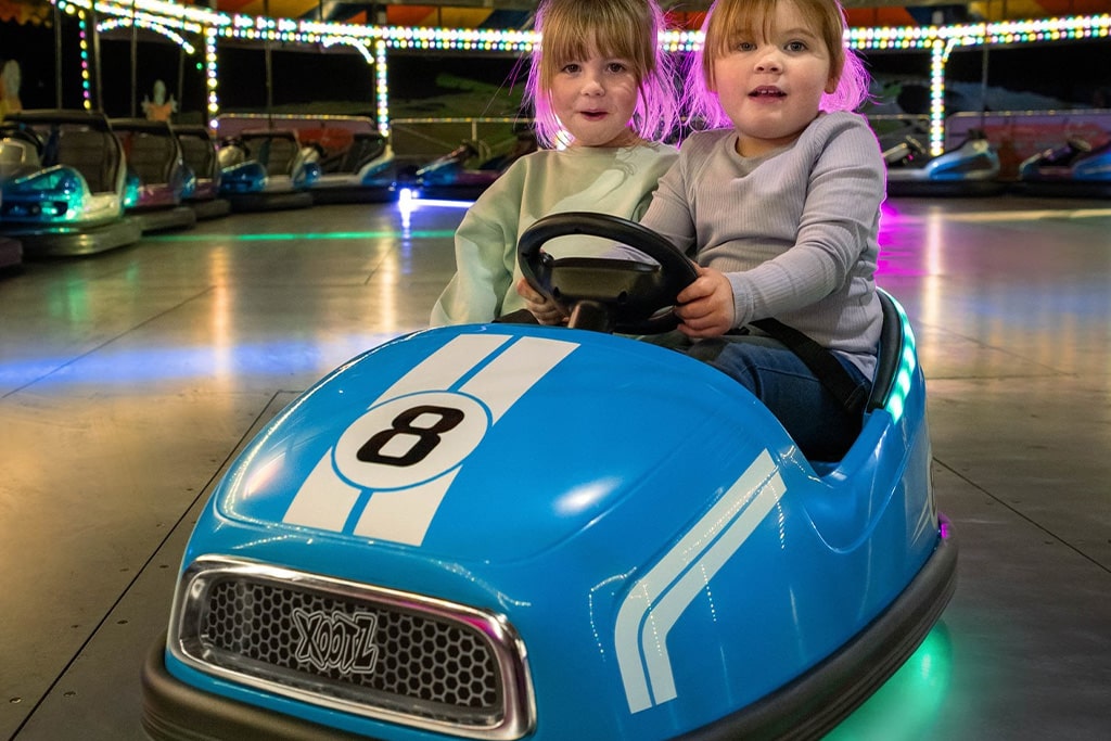 Children riding a childrens bumper car designed for young kids, featuring low speed and enhanced bumper car protection