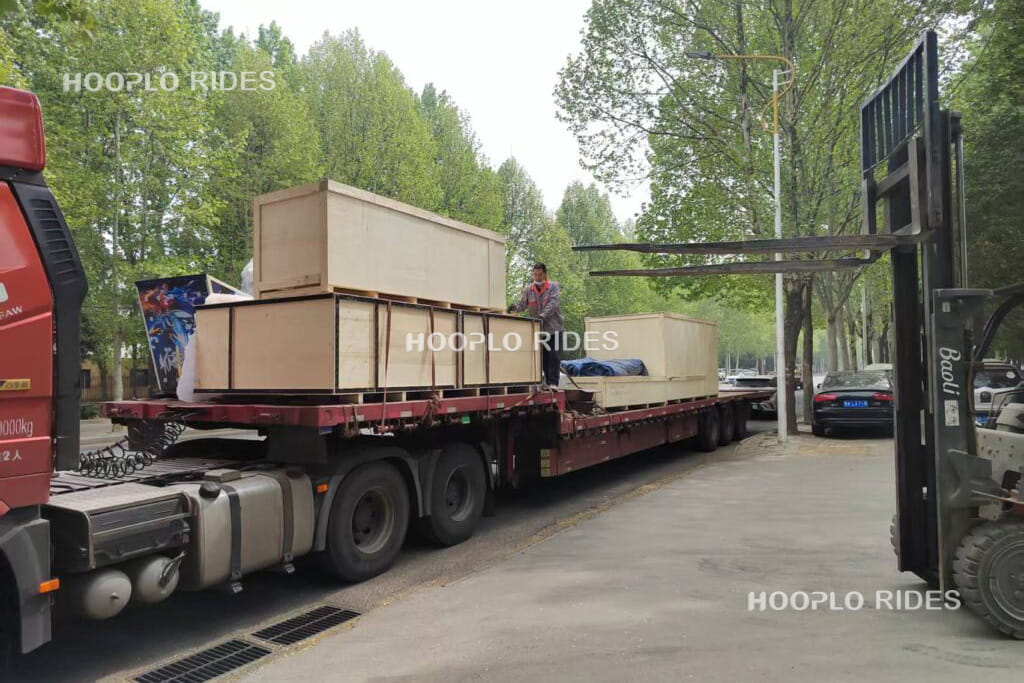 Packed amusement rides in wooden crates being loaded onto truck for shipment