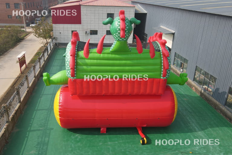 Back view of dragon theme inflatable slide showing air blower connection and reinforced stitching details