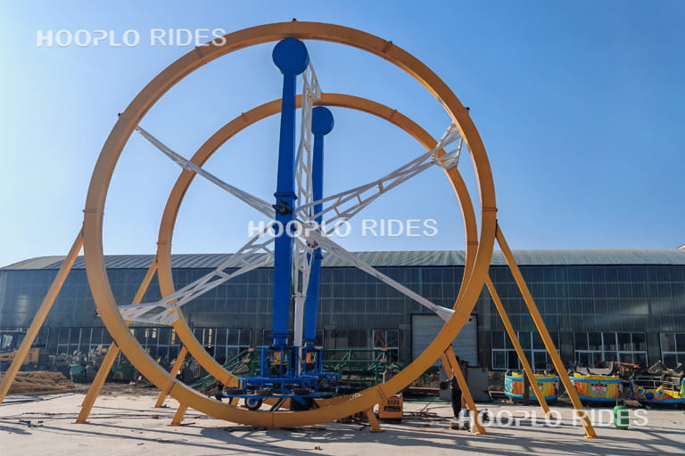 Front view of Human Gyroscope Ride during factory test displaying circular rotation frame