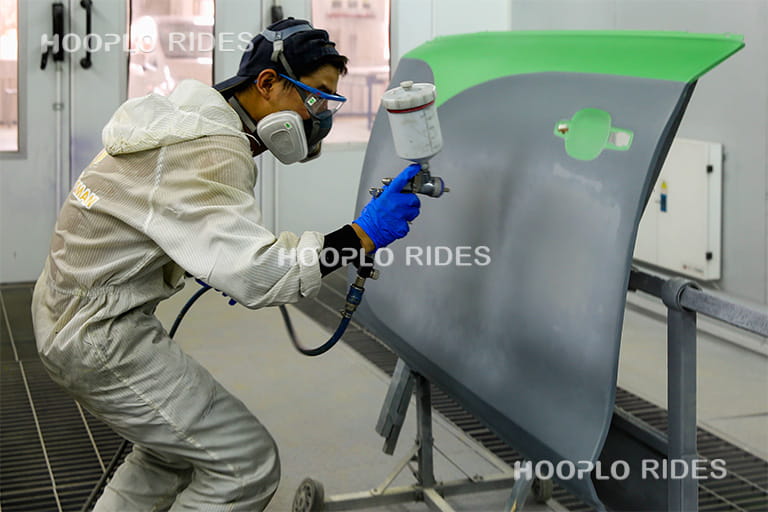 Technician performing sandblasting and surface treatment on pirate ship ride components to ensure smooth finishing and anti-rust protection