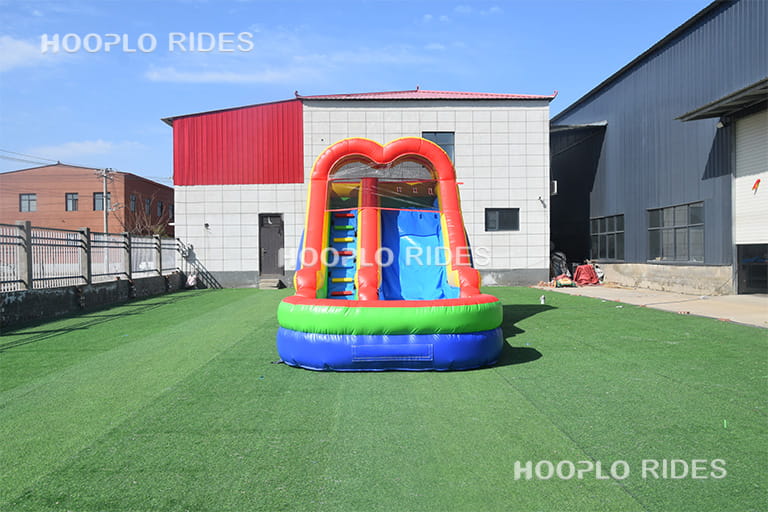 Front view of rainbow inflatable slide with bright colors for inflatable amusement parks