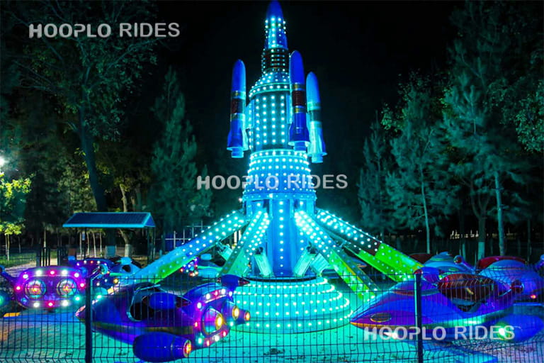 Classic self-control plane ride operating at night in a Nigeria amusement park with bright LED lighting effects.