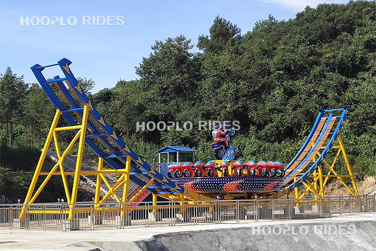 Side view of a 24 seats Disk'O ride in an amusement park before operation, showing the circular seating platform and track structure.