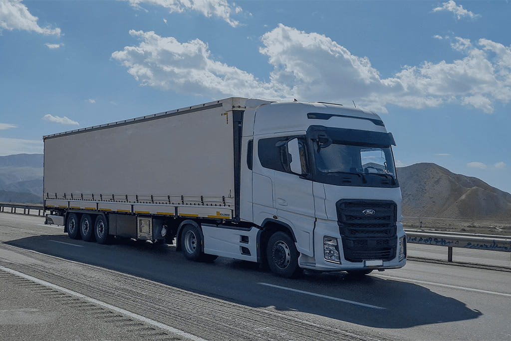 Cargo truck transporting containers on highway, representing land transportation for amusement rides and amusement equipment