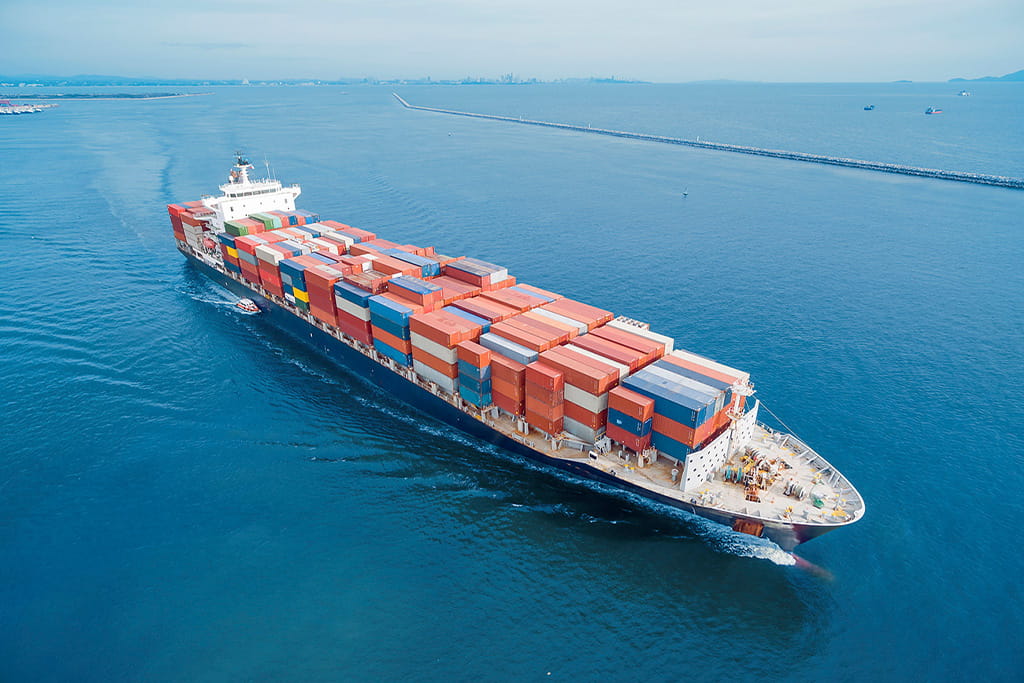 Container ship transporting cargo by sea, representing sea freight shipping method for amusement rides and amusement equipment