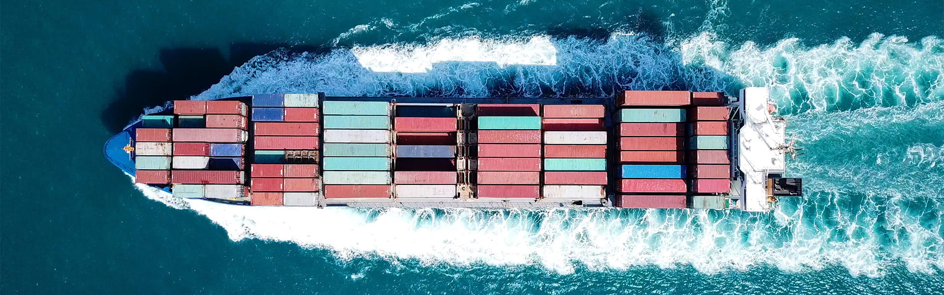 Container ship transporting cargo containers across the ocean, representing global shipping and transportation for amusement rides and amusement equipment