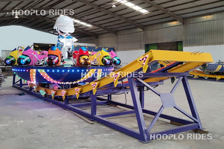 Mini Disk'O ride being tested in the factory testing area before delivery, showing the rotating platform moving along the track.