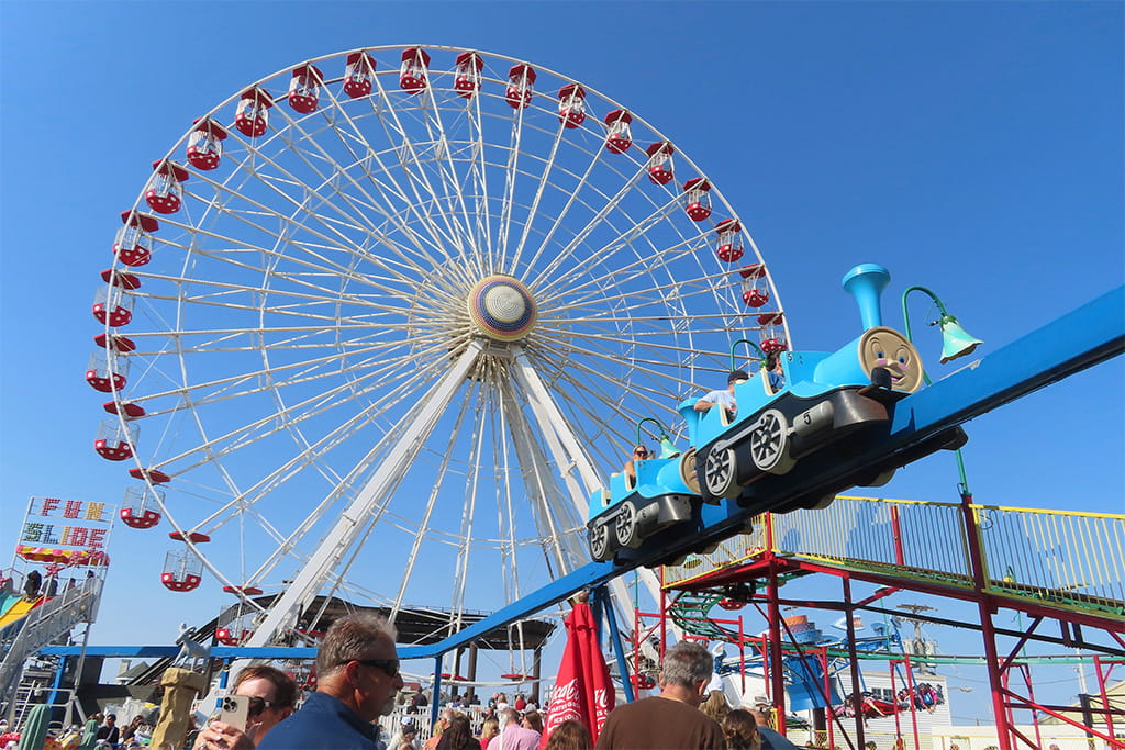 Visitors enjoying various attractions at an amusement park, experiencing fun and excitement.