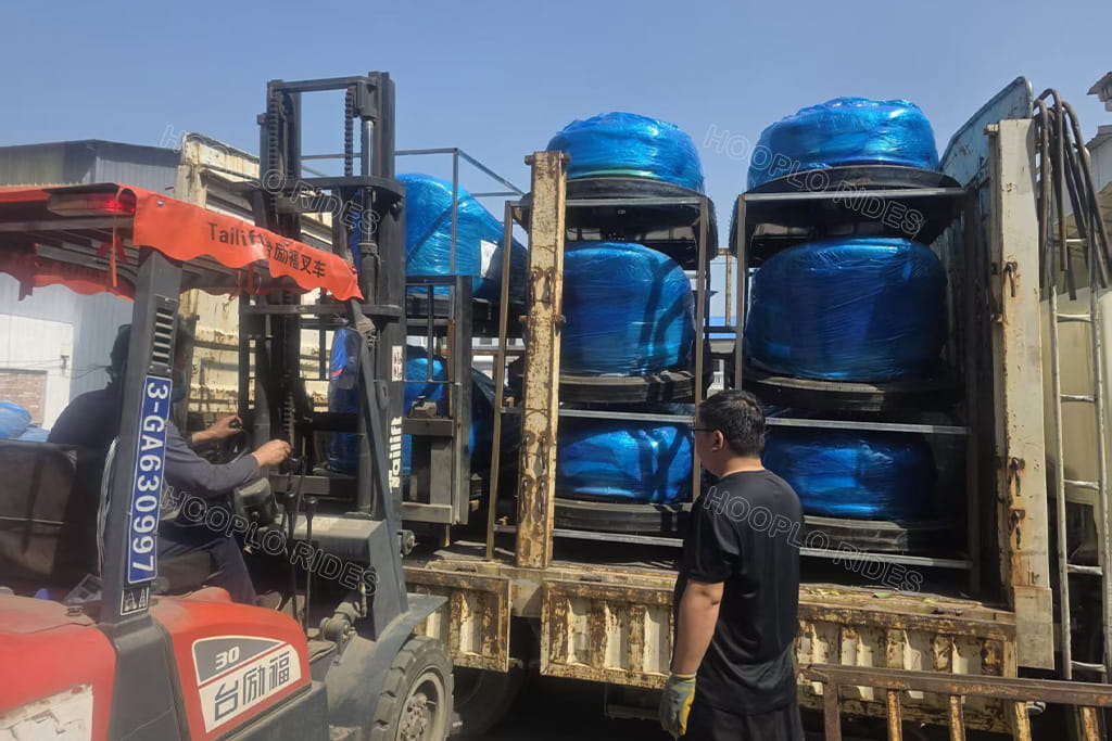 Finished ground grid bumper cars loading on truck, export packaged shipment depart factory to Uzbekistan amusement project