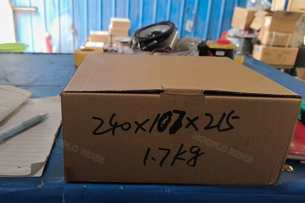 Replacement motor controller for a Hooplo Rides trackless train being weighed, packed, and prepared for shipment from the factory to a customer in Russia.